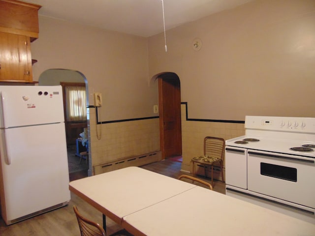 kitchen featuring tile walls, white appliances, and light hardwood / wood-style flooring