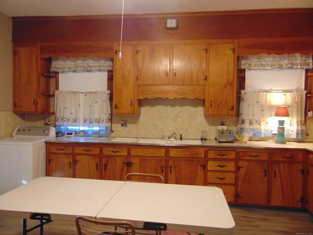 kitchen featuring tasteful backsplash, dark hardwood / wood-style floors, sink, and washer / dryer