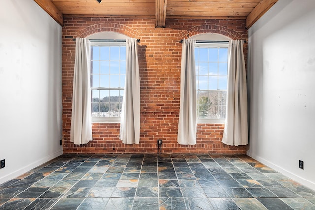 unfurnished room featuring brick wall, wood ceiling, and plenty of natural light