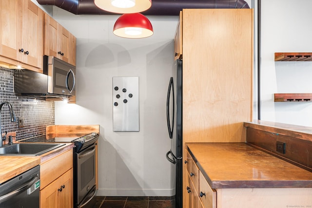 kitchen with black appliances, backsplash, dark tile patterned flooring, and sink