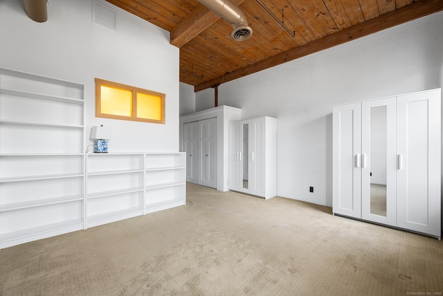 unfurnished living room with high vaulted ceiling, beam ceiling, light colored carpet, and wooden ceiling