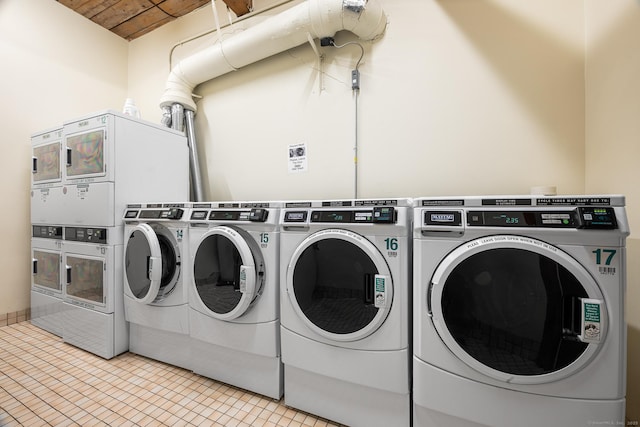 laundry room with light tile patterned floors, stacked washer / drying machine, and washer and clothes dryer