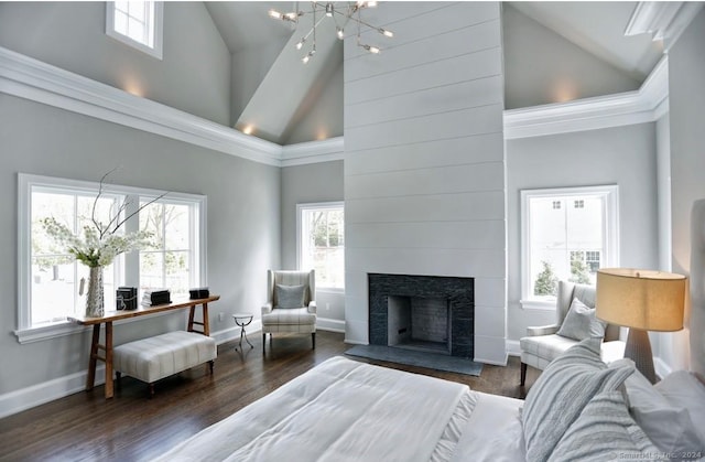 living room featuring a healthy amount of sunlight, dark wood-type flooring, a tiled fireplace, and high vaulted ceiling