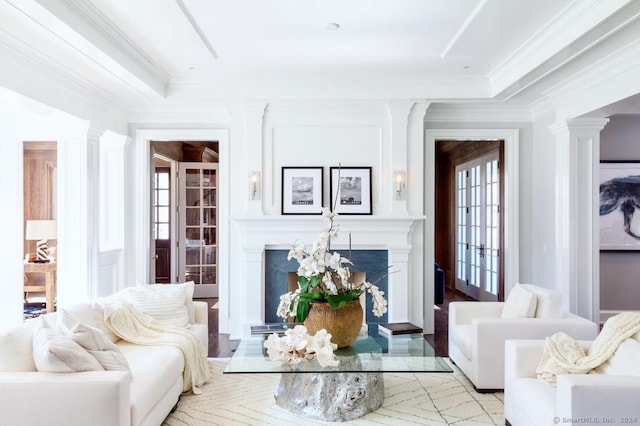 living room with decorative columns and crown molding