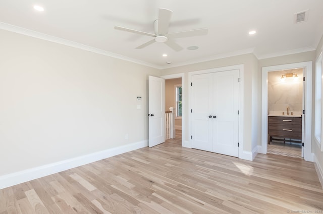 unfurnished bedroom with ceiling fan, light wood-type flooring, ornamental molding, connected bathroom, and a closet