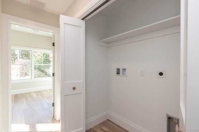 clothes washing area with wood-type flooring, hookup for a washing machine, and electric dryer hookup