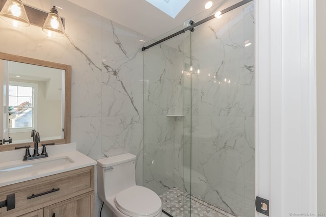 bathroom with a skylight, a shower with door, vanity, and toilet