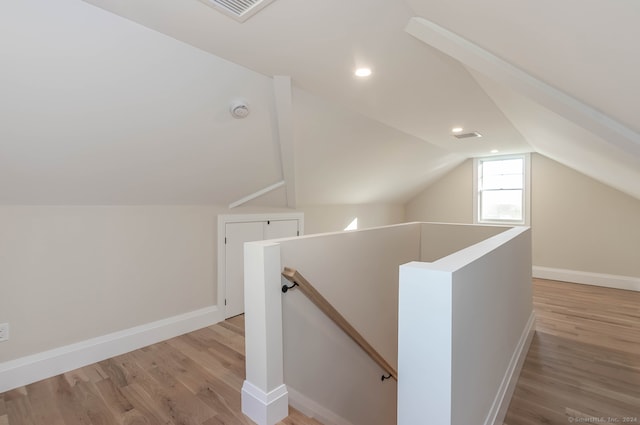 bonus room with vaulted ceiling and light hardwood / wood-style flooring