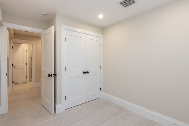 hallway with light hardwood / wood-style floors