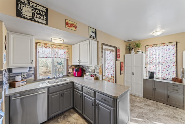 kitchen with white cabinets, stainless steel dishwasher, gray cabinetry, and sink