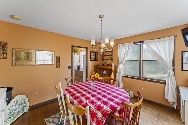 dining space featuring a chandelier, dark hardwood / wood-style flooring, and a baseboard radiator