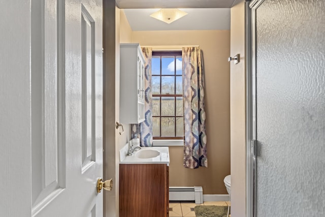 bathroom with baseboard heating, tile patterned floors, vanity, and toilet