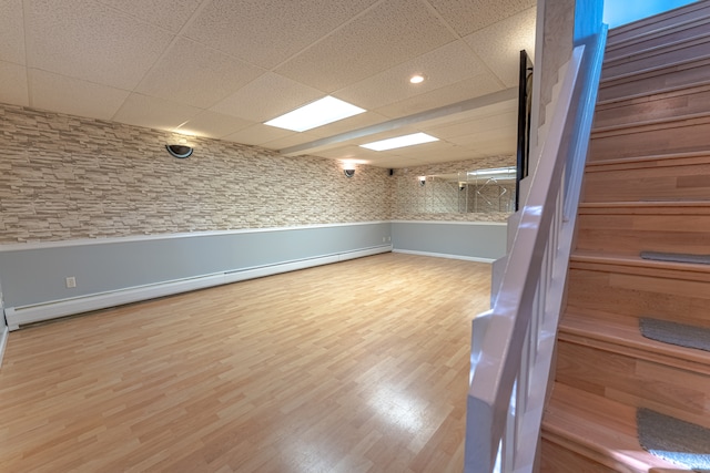 spare room with hardwood / wood-style flooring, a paneled ceiling, and a baseboard radiator