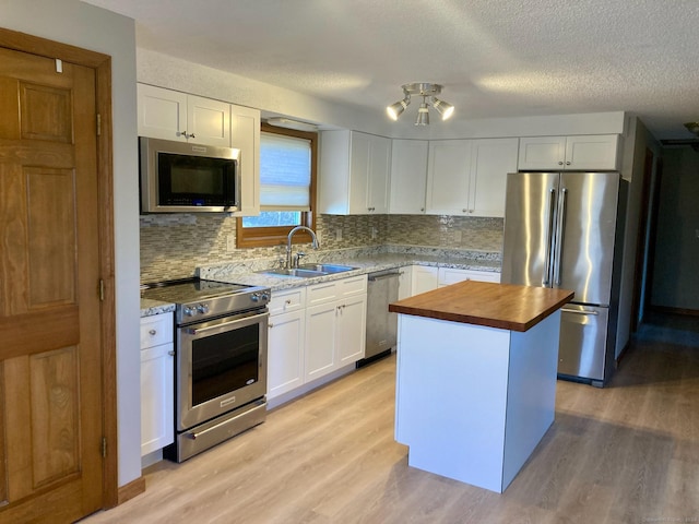 kitchen featuring white cabinetry, sink, a kitchen island, and appliances with stainless steel finishes