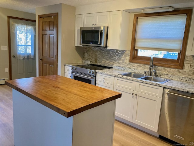 kitchen with white cabinets, plenty of natural light, a center island, and stainless steel appliances