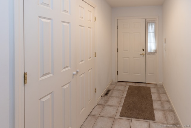 doorway to outside with light tile patterned floors