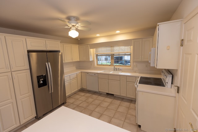 kitchen featuring white appliances, ceiling fan, sink, light tile patterned floors, and white cabinetry