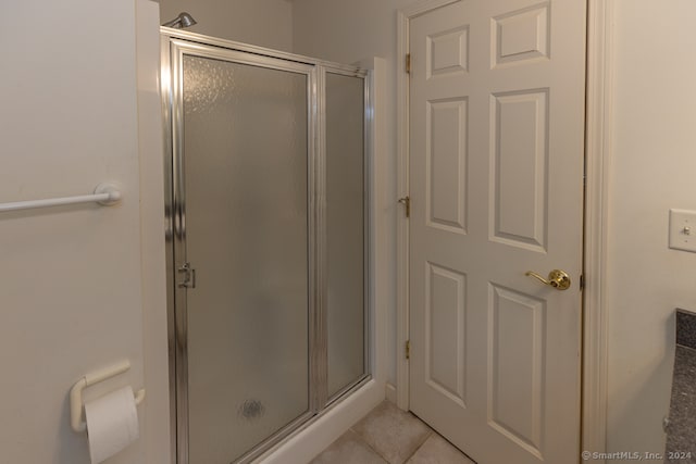 bathroom featuring tile patterned floors and a shower with shower door