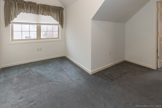 bonus room featuring dark carpet and lofted ceiling