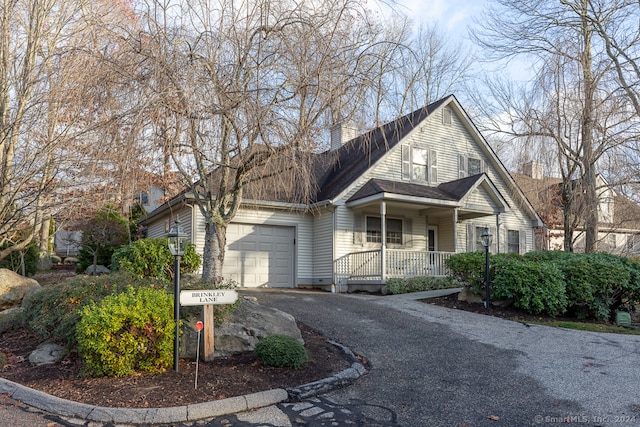 front of property featuring covered porch and a garage