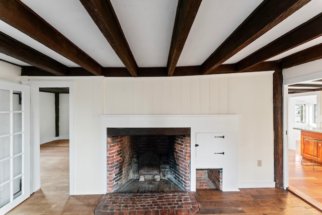 details featuring a fireplace, wood-type flooring, beam ceiling, and wood walls