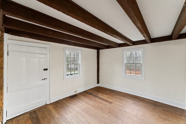 entryway featuring a wealth of natural light, wood-type flooring, and beam ceiling