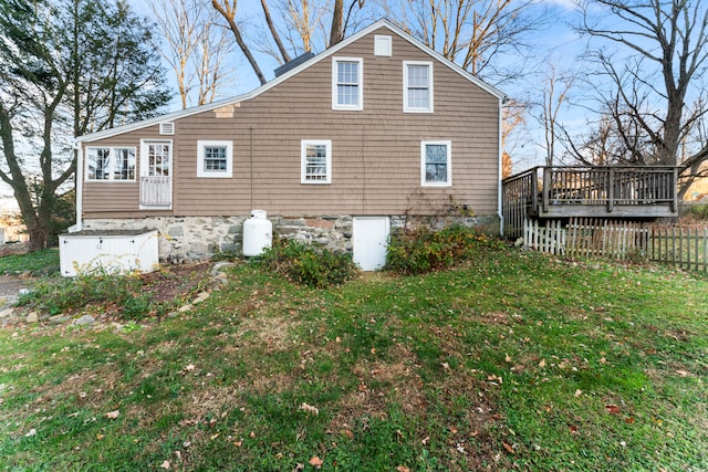 back of house featuring a wooden deck and a lawn