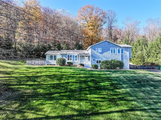 view of front of home featuring a front lawn and a deck