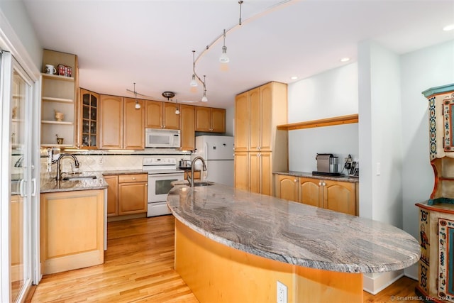 kitchen featuring tasteful backsplash, sink, light hardwood / wood-style floors, a center island, and white appliances