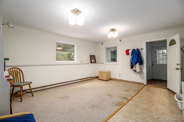 interior space with a baseboard heating unit and light colored carpet