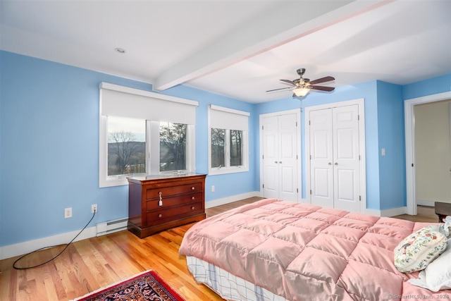 bedroom with light wood-type flooring, multiple closets, ceiling fan, beamed ceiling, and baseboard heating