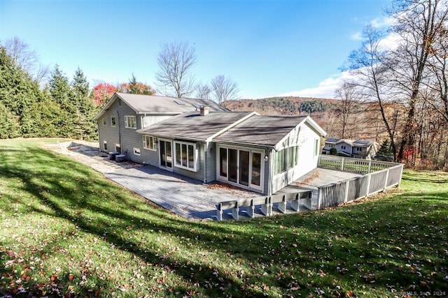 back of house with a patio area, a sunroom, and a lawn