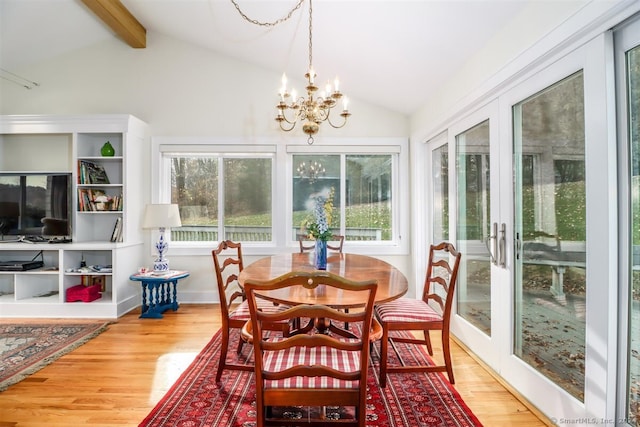 sunroom / solarium featuring lofted ceiling with beams and an inviting chandelier