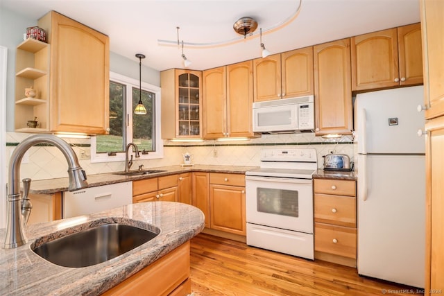 kitchen featuring sink, light brown cabinetry, light wood-type flooring, and white appliances