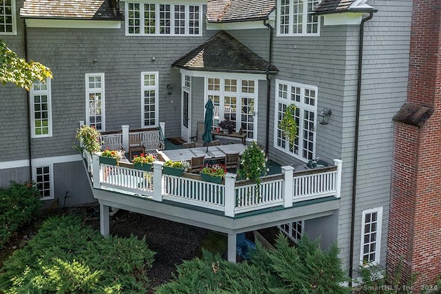 rear view of house with a chimney and a wooden deck