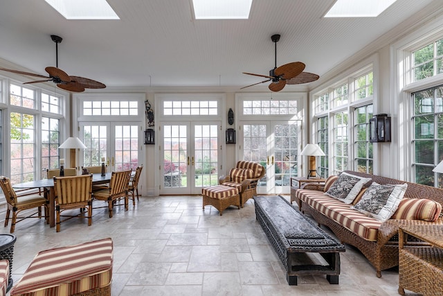 sunroom featuring a ceiling fan, a skylight, and french doors