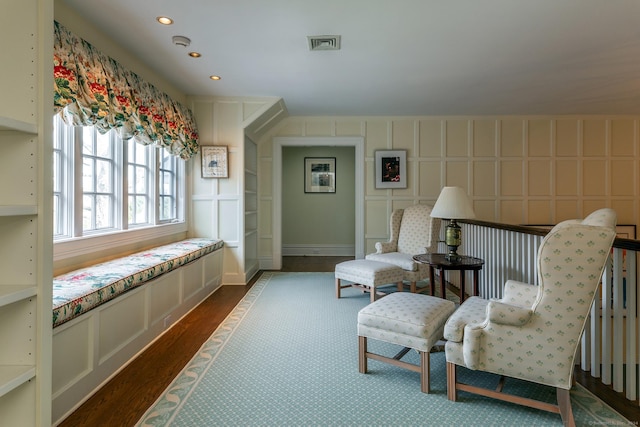 living area with visible vents, a decorative wall, dark wood-style flooring, and recessed lighting