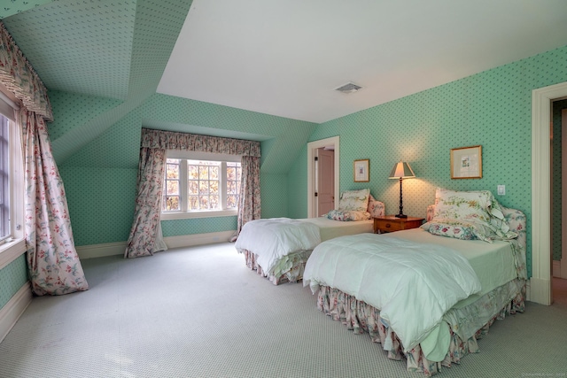 bedroom with wallpapered walls, baseboards, visible vents, vaulted ceiling, and carpet floors