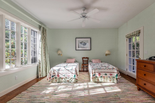 bedroom featuring ceiling fan, baseboards, and wood finished floors