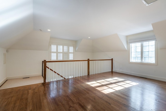 additional living space featuring baseboards, visible vents, wood finished floors, vaulted ceiling, and recessed lighting