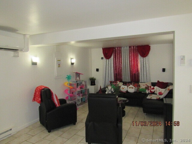 living room with electric panel and a wall mounted air conditioner