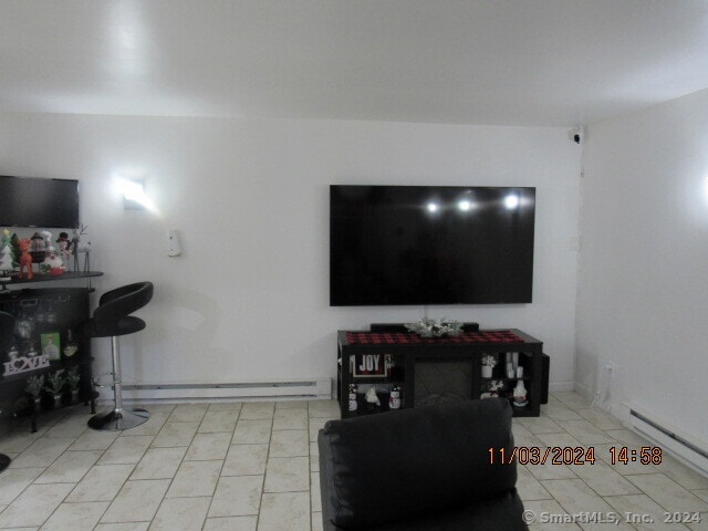 tiled living room featuring baseboard heating