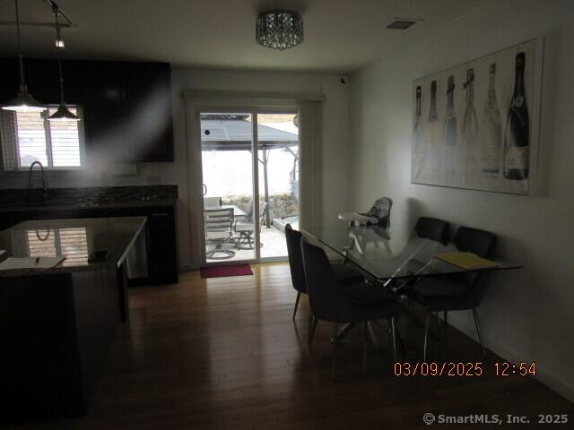 dining room featuring plenty of natural light, visible vents, and wood finished floors