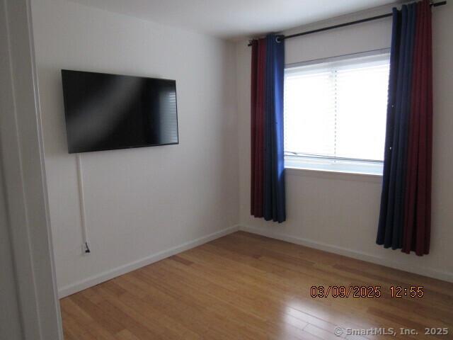 unfurnished room featuring baseboards and wood finished floors