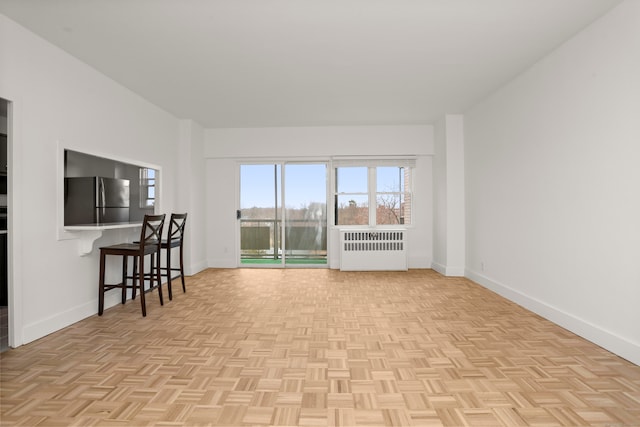 living room with light parquet floors and radiator