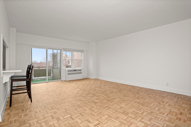 empty room with light parquet floors and radiator