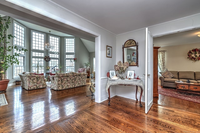 living room with hardwood / wood-style flooring, ornamental molding, and a notable chandelier