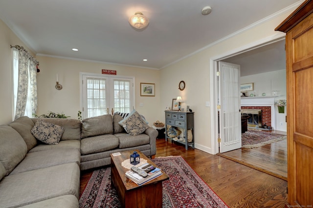 living room featuring a fireplace, dark wood-type flooring, ornamental molding, and french doors