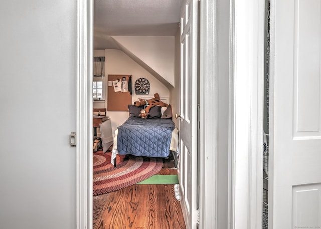 bedroom with wood-type flooring and vaulted ceiling