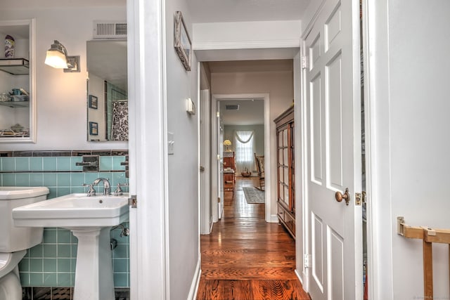 bathroom with tile walls, hardwood / wood-style floors, and toilet